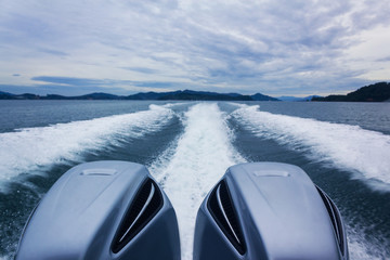 The engines of a motorboat. The speedboat trace on the water. Horizontal outdoors shot.