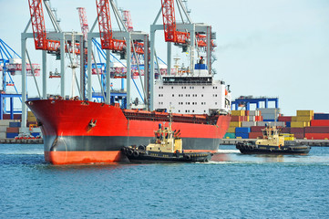 Tugboat assisting bulk cargo ship