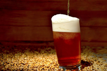 un vaso de cerveza roja con espuma recien servido