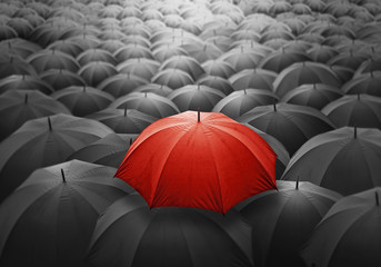 Outstanding Red umbrella among many dark crowd. Selective focus, shallow depth of field.