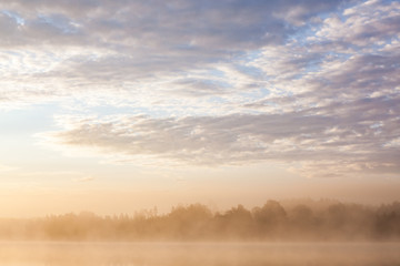 Fototapeta na wymiar Sunrise at foggy lake