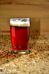 un vaso de cerveza roja con espuma recien servido