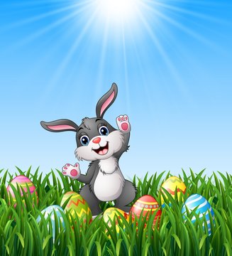 Cartoon rabbit with easter eggs in the grass