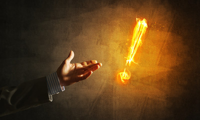 Concept of attention or punctuation with burning exclamation mark on dark background