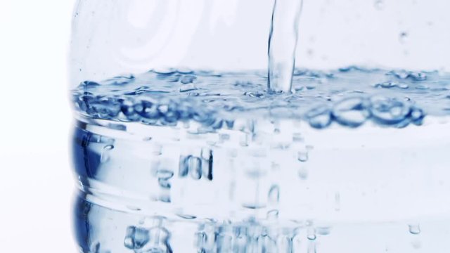 A bottle is being filled with water