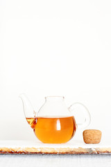 Glass teapot of black tea on a white table isolated on white background. Copy space.