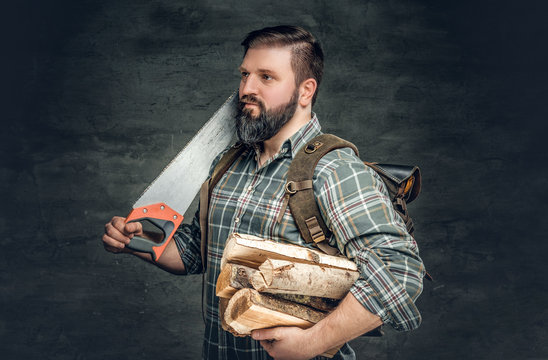 A man holds fire woods and hand saw.