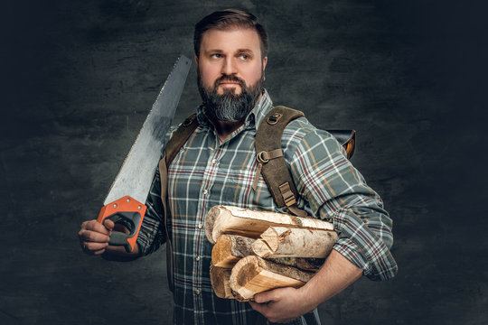 A man holds fire woods and hand saw.