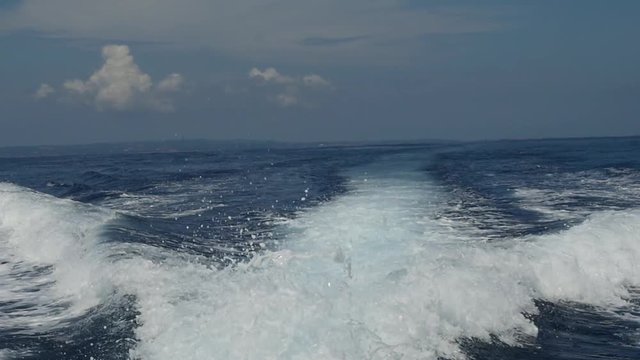 Waves from a motor boat against a background of the sea horizon in Indonesia. Cruise on the blue water. Extreme sport. Speed Regatta.