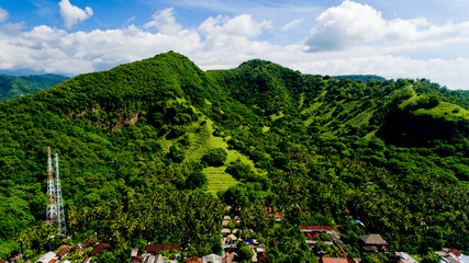 Naklejka na ściany i meble Aerial landscape view of green mountains and blue sky with clouds at village Candidasa, Bali, Indonesia.