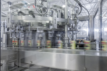 close-up of conveyor belt in motion at production and bottling of drinks in tin cans. production and bottling of drinks in tin cans