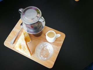 Hot coffee and bread on the black table.