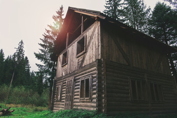 One big old house in the forest at sunset