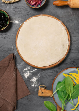 Raw pizza dough with set ingredients for cooking vegetarian pizza