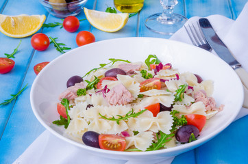 Pasta salad with tuna, olives, cherry tomatoes and arugula