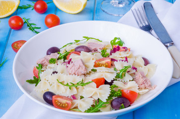 Pasta salad with tuna, olives, cherry tomatoes and arugula