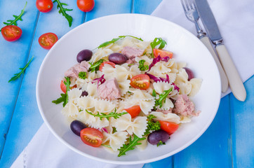 Pasta salad with tuna, olives, cherry tomatoes and arugula