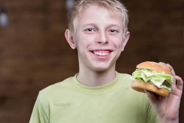 A teenager eating a sandwich