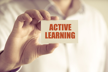 Businessman holding ACTIVE LEARNING message card