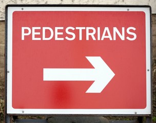 Sign for pedestrians to divert using a directional arrow, as workers have disrupted the shortest path