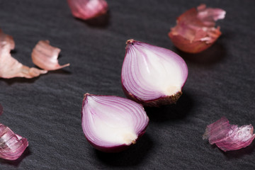 Cooking ingredients: cinnamon sticks and garlic on black stone table.