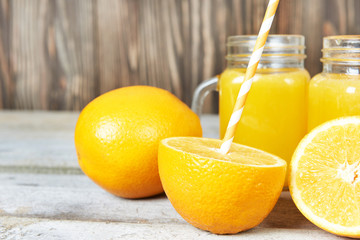 Obraz na płótnie Canvas Orange fruit and glass of orange juice on wooden background