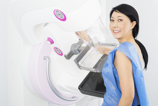 Smiling Woman Undergoing Mammogram X-ray Test