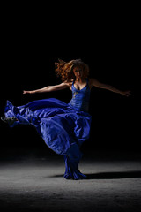 The dancing girl in the darkness, performs pirouettes. © Alexander