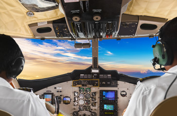 Pilots in the plane cockpit and sunset