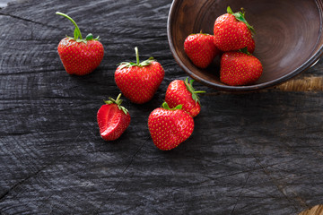 Red fresh strawberries on black rustic wood background