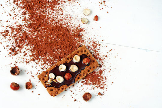 Healthy snack: homemade sandwich with chocolate and hazelnut on a rye crispbread over white table. Copy space.