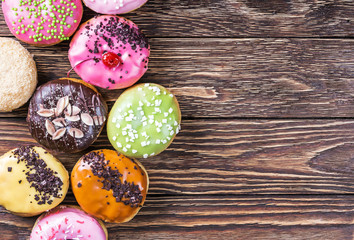 Glazed donuts with different fillings on a wooden table