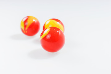 Three red yellow marbles isolated on white background
