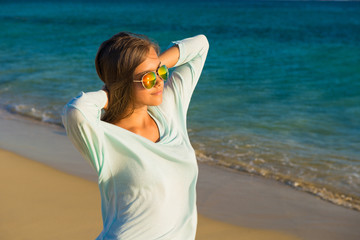  Young pretty girl. Young smiling woman outdoors portrait. Close. ocean. Happy beach  woman living a healthy lifestyle. Beautiful young girl In sunglasses with hair in the wind.
