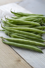 Bunch of fresh green beans on the wooden background