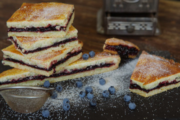 Homemade traditional sweet autumn raspberry tart pie with jam on vintage wooden table background