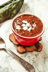 Chocolate pudding in a red bowl, with coconut.Selective focus.
