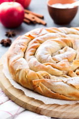 Round burek pie with an apple on a dark background. Traditional Serbian cuisine. Selective focus. Top view.