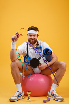 Portrait of a sports man sitting on a fitness ball