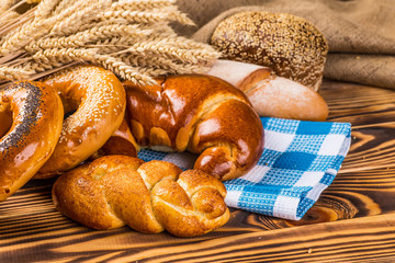 Assortment of baked bread on wooden table background