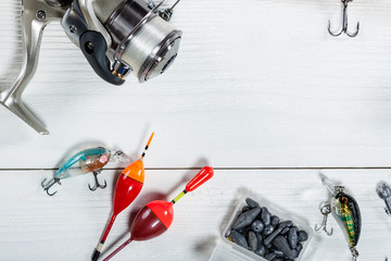 Fishing accessories on a wooden background. © Alex Ishchenko
