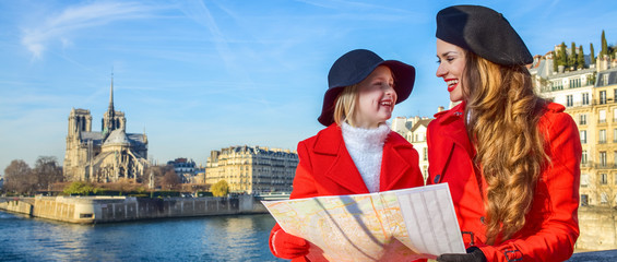 trendy mother and daughter travellers in Paris, France with map