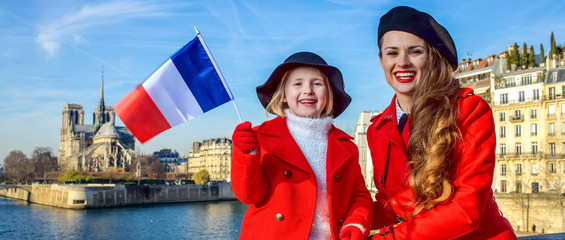 mother and daughter travellers in Paris, France showing flag