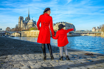mother and daughter travellers in Paris pointing at something