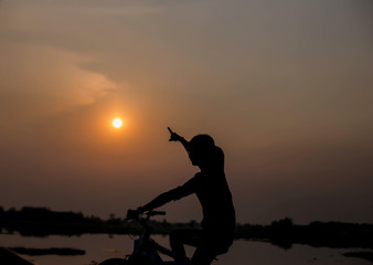 Obraz na płótnie Canvas Woman biking hands at sunset. 