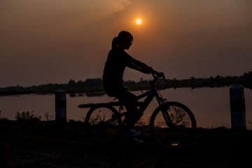 Obraz premium Woman biking hands at sunset. 