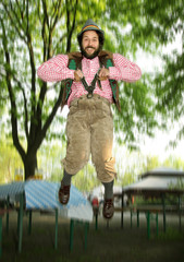 Bavarian Bearded Guy in a Biergarten. Jumping after probably a few too many beers