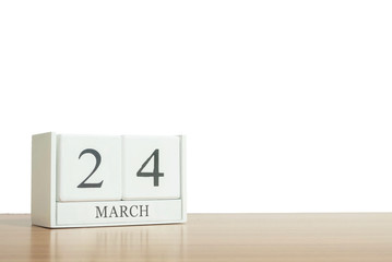 Closeup surface white wooden calendar with black 24 march word on blurred brown wood desk isolated on white background with copy space , selective focus at the calendar