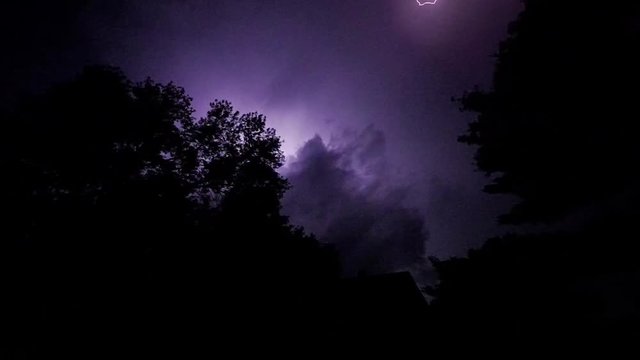 Lightning branches across the night sky in slow motion.