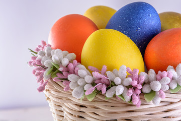 Bright easter eggs in wicker basket